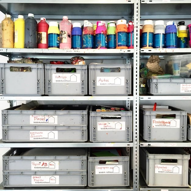 Interior view of a small, tidy storage unit filled with neatly stacked boxes. Labels are visible on the boxes. Focus on efficient space utilization within the unit.