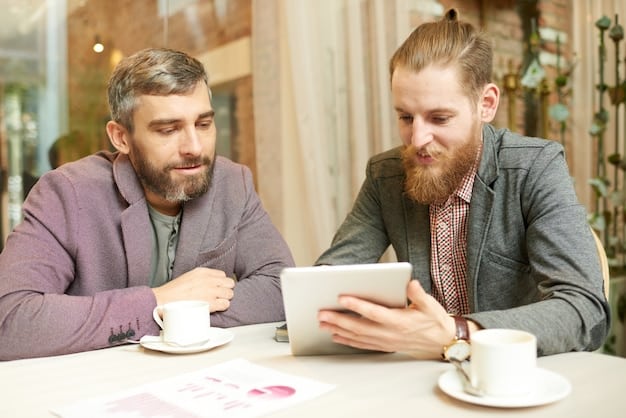 Two freelancers discussing contract terms over coffee, with one pointing at a specific clause on a tablet screen. The atmosphere is collaborative and professional.