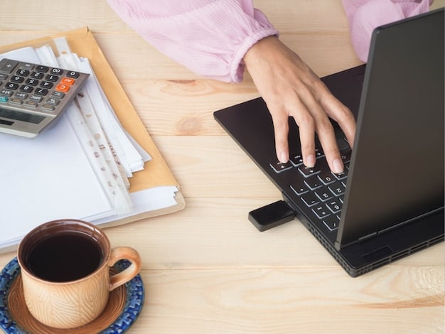 A close-up of a freelancer's hands typing on a laptop, with a calendar and calculator visible in the background, emphasizing the financial aspect of freelancing.