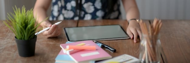 A freelancer reviewing an email draft on a tablet, with sticky notes around their workspace, suggesting a careful and organized approach to crafting professional emails.