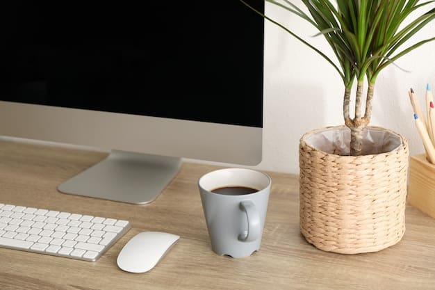 A clean and minimalist desk setup with a laptop, external monitor, keyboard, and mouse. A cup of coffee and a small plant are also on the desk.