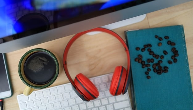 A close-up of noise-canceling headphones on a desk with a laptop. The background is slightly blurred to emphasize the focus on the headphones.