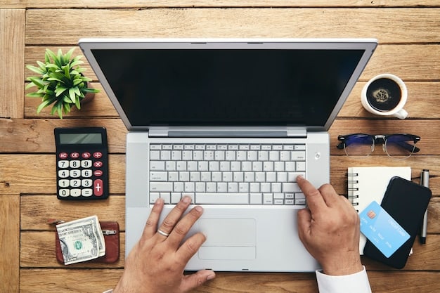 An overhead shot of a person's hands using a laptop to manage their finances and set up automated transfers to various sinking fund accounts.