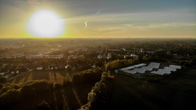 A panoramic view of a thriving city skyline at sunset, with numerous solar panels visible on rooftops and a few modern wind turbines integrated into the urban landscape, symbolizing a sustainable, modern future.