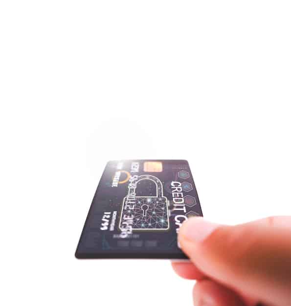 A close-up of a hand holding a credit card, emphasizing the intricate financial details and security features.