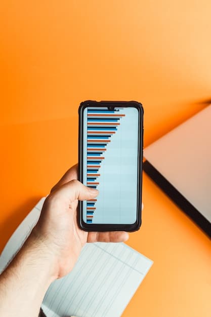 A person's hands holding a modern smartphone with a budgeting app open, showing graphs and numbers, emphasizing digital financial tracking and management.