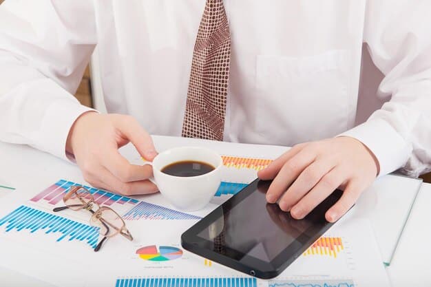 A person attentively reviewing financial documents and charts on a tablet, with a calculator and coffee cup beside them, suggesting strategic financial planning.