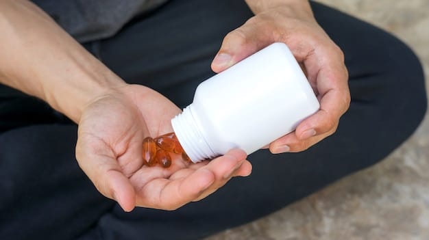 A hand holding a small bottle of acetaminophen pills, with a blurred background of a living room, suggesting everyday use. The focus is on the label, which has a prominent 