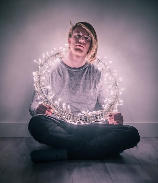 A person, surrounded by subtle glowing light, demonstrably calming their mind through meditation, illustrating the internal benefits of the practice on their well-being.