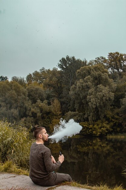 A person enjoying a clear, deep breath in a serene natural setting like a park, highlighting the improved breathing and sense of freedom after quitting smoking.