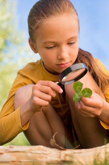 A child excitedly using a magnifying glass to examine a plant in a community garden, demonstrating hands-on nature exploration for STEM learning.