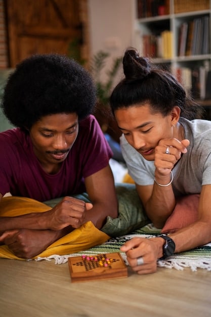 An adult student working one-on-one with a volunteer tutor at a community literacy center, both smiling and engaged in a reading exercise.