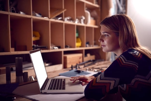 A student working diligently on a laptop in a modern study space, surrounded by academic resources, illustrating the focus and dedication required for graduate studies and funding applications.