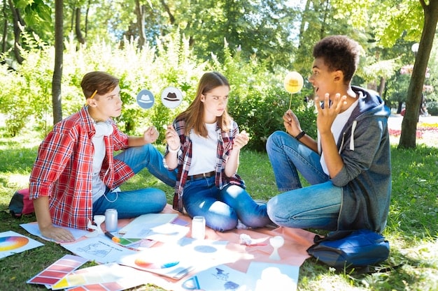 A group of enthusiastic students presenting their science fair project, which involves a hands-on experiment, to a small audience in a vibrant and interactive summer camp setting.